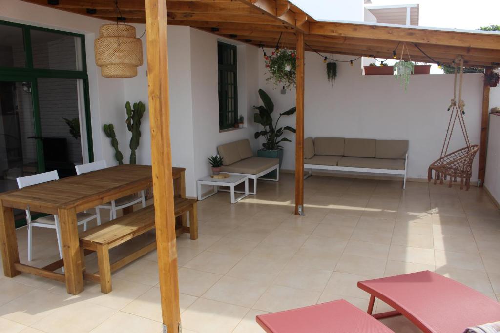 een patio met een houten tafel en stoelen in een huis bij Casa La Esperanza in Playa Blanca