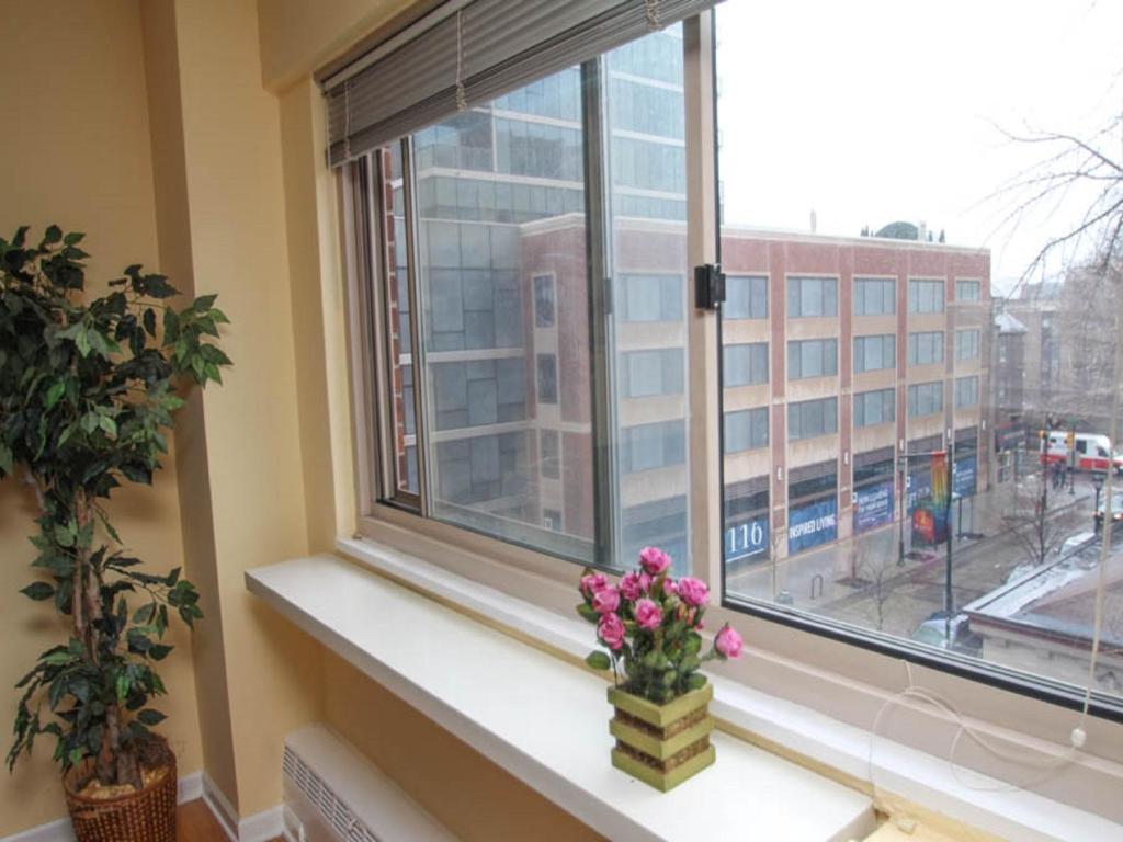 a window with a vase of flowers on a window sill at Luxury Two Bedroom by Rittenhouse Square in Philadelphia