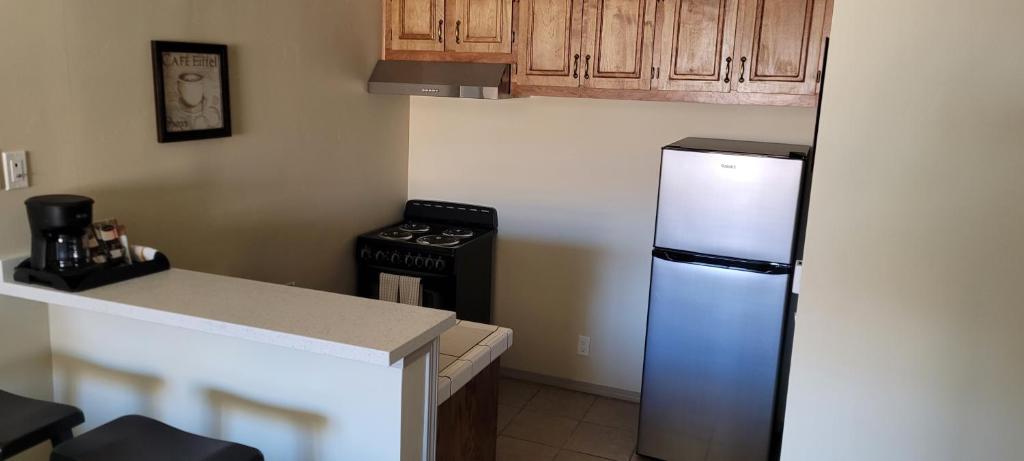 a kitchen with a refrigerator and a stove at Bishop Village Motel in Bishop