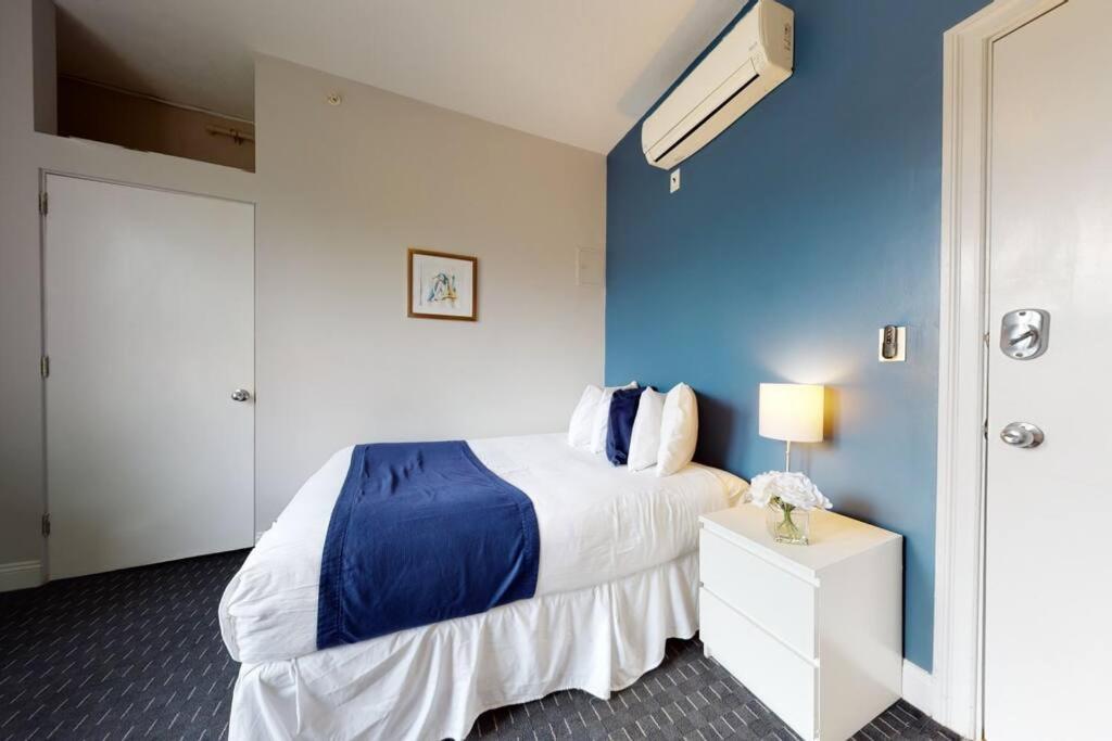 1 dormitorio con 1 cama con pared azul en Charming Studio in Boston Brownstone, #44 en Boston
