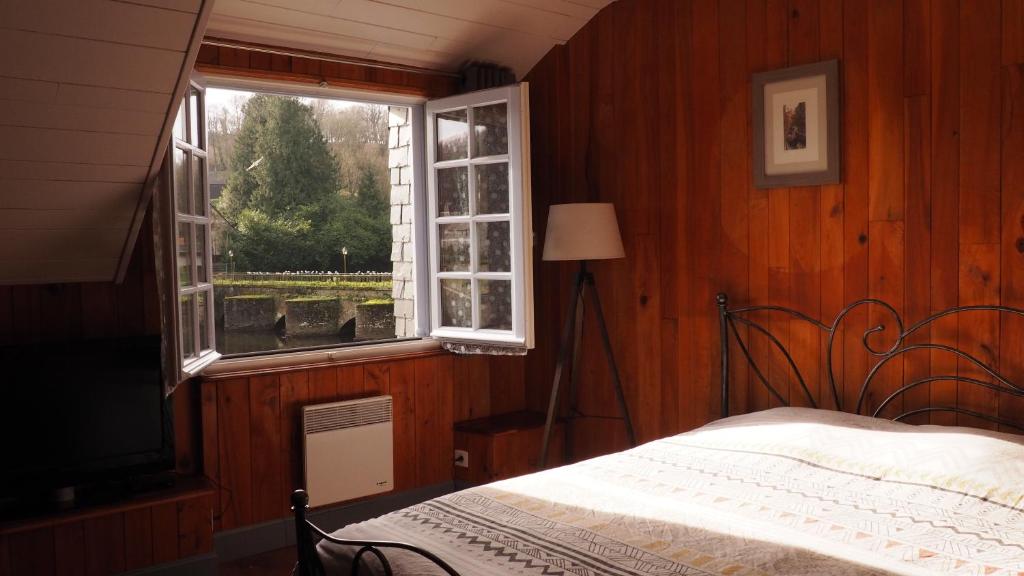 Schlafzimmer mit einem Bett und einem Fenster in der Unterkunft Au Pied du Pont in Châteauneuf-du-Faou