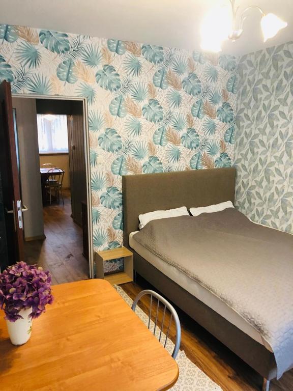 sypialnia z łóżkiem i drewnianym stołem w obiekcie Apartament Gosia w Rogowie