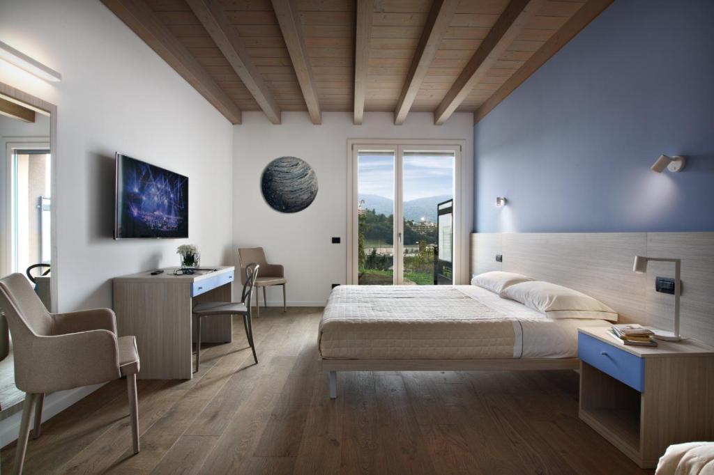 a bedroom with a large bed and a desk and a desk at Residence Caffè Maya in Maslianico