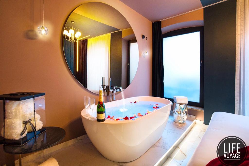 a bathroom with a tub and a large mirror at LIFE VOYAGE & SPA by Life Renaissance in Strasbourg