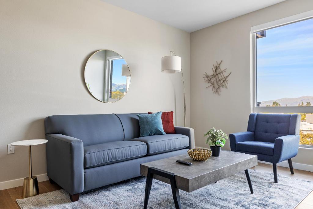 a living room with a blue couch and a table at Kasa University-Airport Santa Clara in Santa Clara