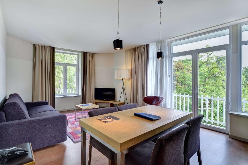 ein Wohnzimmer mit einem Tisch und einem Sofa in der Unterkunft Radisson BLU Balmoral in Spa
