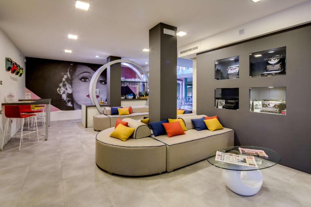 a living room with a couch with colorful pillows at La Villa - Sure Hotel Collection by Best Western in Ivrea