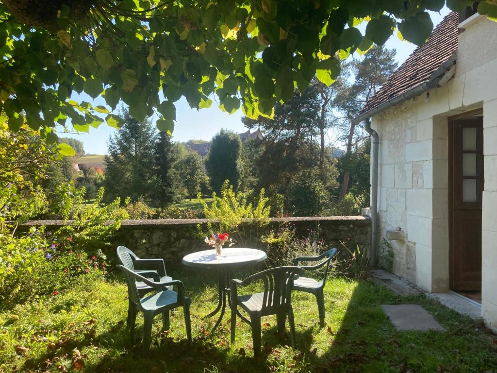 - une table et des chaises dans la cour d'une maison dans l'établissement L’Alcalys - Maison de vacances au vert - Sans TV, à Saint-Aignan
