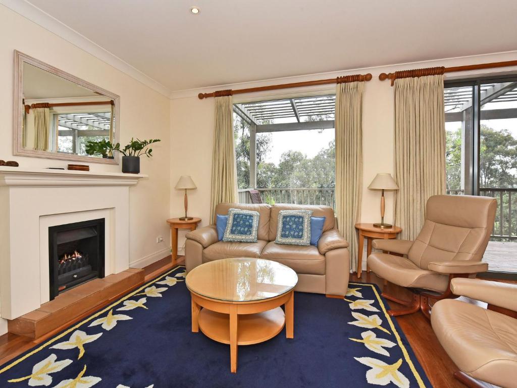 a living room with a couch and chairs and a fireplace at Villa 2br Prosecco Villa located within Cypress Lakes Resort in Pokolbin