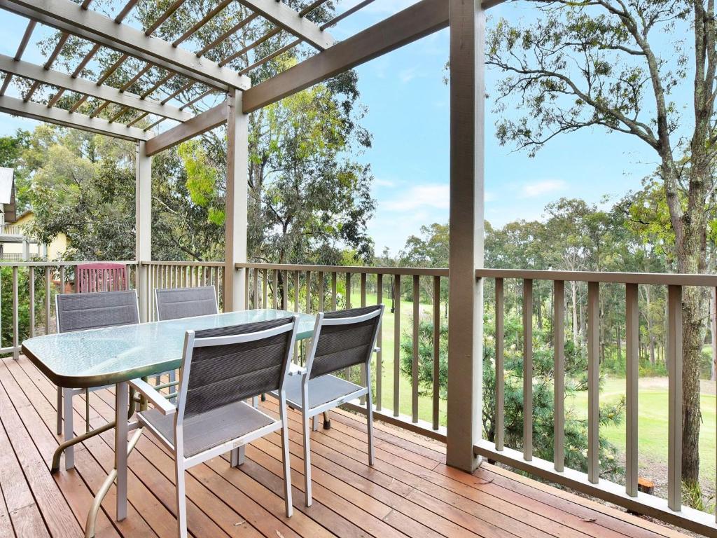 un tavolo e sedie su una terrazza con pergolato di Villa 2br Prosecco Villa located within Cypress Lakes Resort a Pokolbin