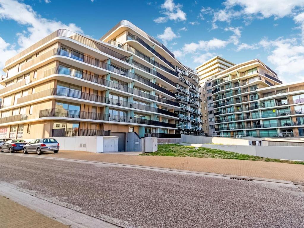 um prédio de apartamentos com carros estacionados em frente em Luxurious Crystal Sea View apartment with 2 terraces em Oostende