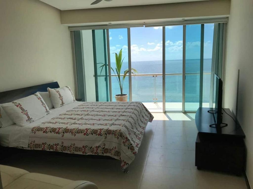a bedroom with a bed and a view of the ocean at Ocean front apartment in Cancun in Cancún