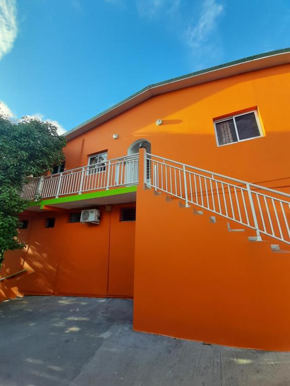 an orange building with a balcony on the side at Chez Lilise 2 in Sainte-Anne
