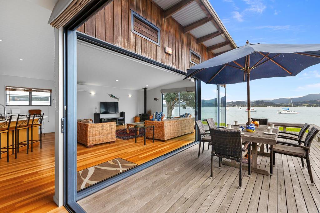 a house with a deck with a table and an umbrella at Omaha Views - Omaha Holiday Home in Omaha