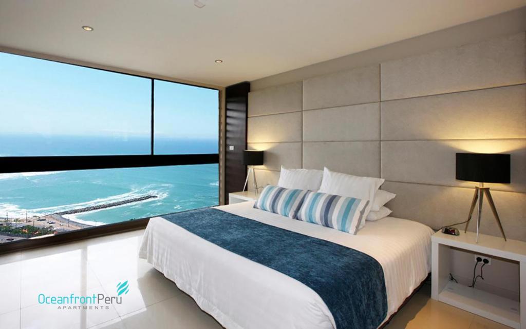 1 dormitorio con cama grande y ventana grande en OceanFront Larcomar Apartments, en Lima