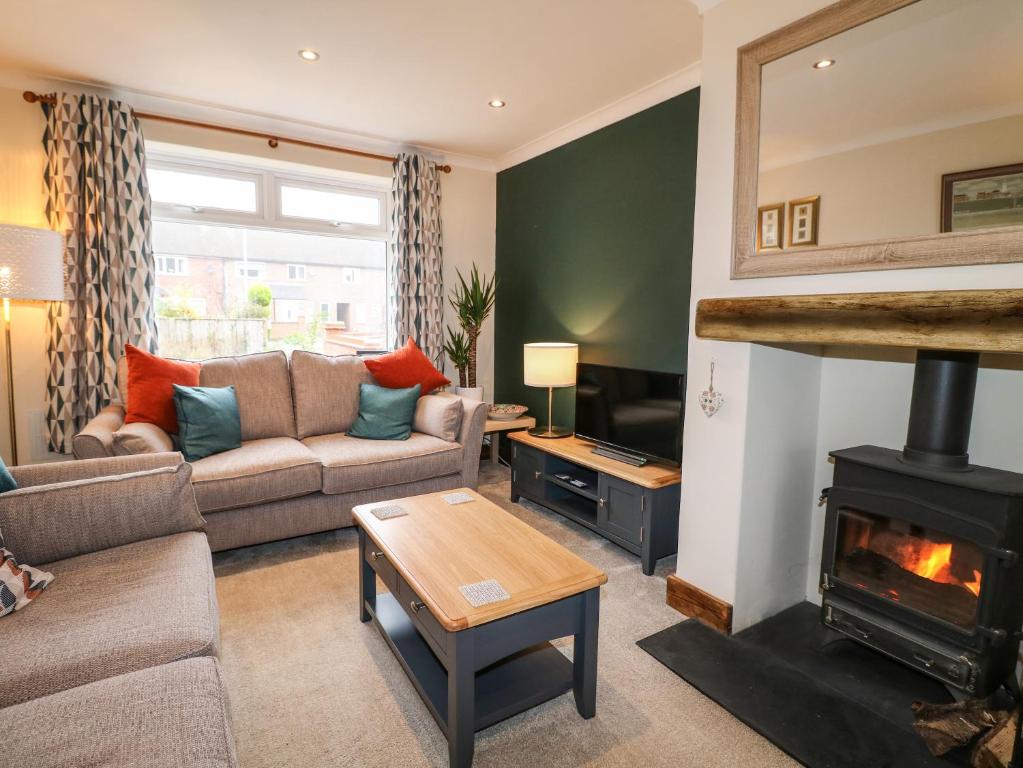 a living room with a couch and a fireplace at The Corner House in Uttoxeter