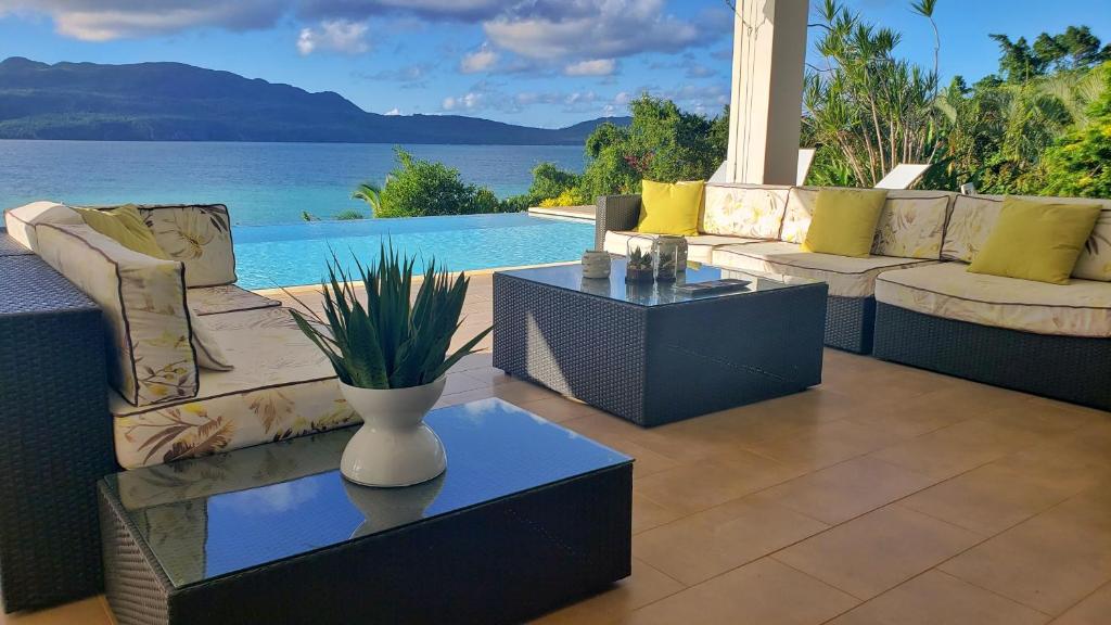 un patio con sofás y vistas al agua en Villa Salamandra, en Las Galeras