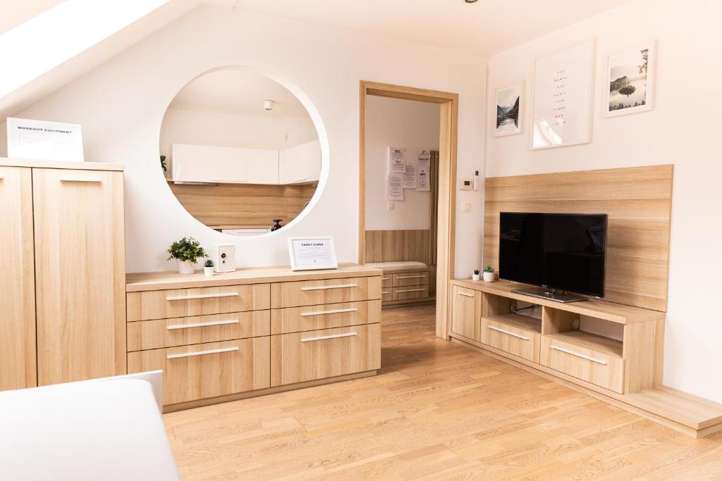 a living room with a tv and a mirror at Vigorous Bled Apartment in Bled