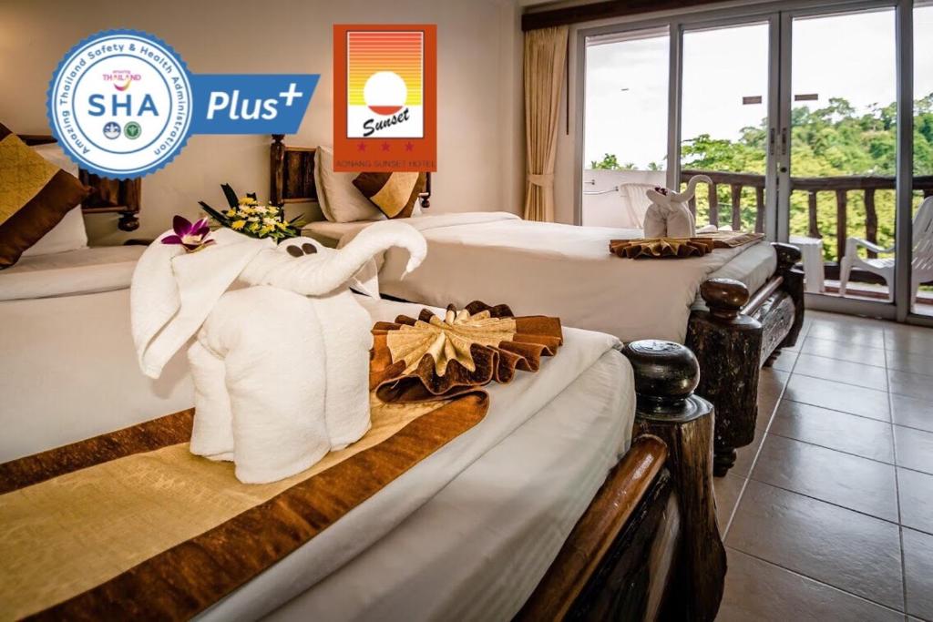 a hotel room with two beds with towels at Aonang Sunset Hotel - SHA Extra Plus in Ao Nang Beach
