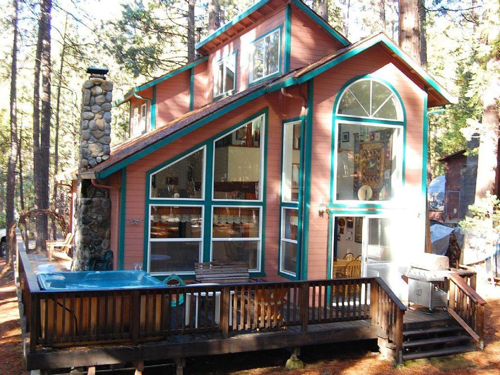 a small house with a hot tub on a deck at Bear Crossing in Wawona