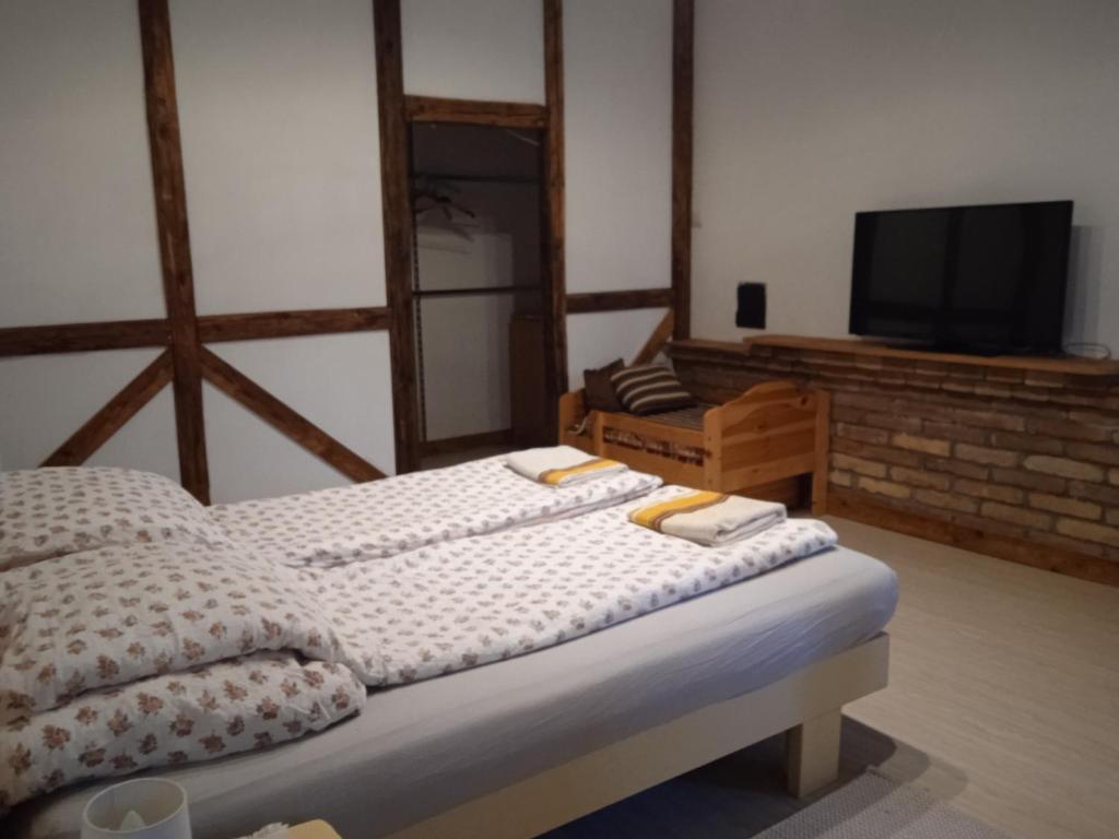 a bedroom with a bed and a tv in it at Veranda Vendégház in Kismaros