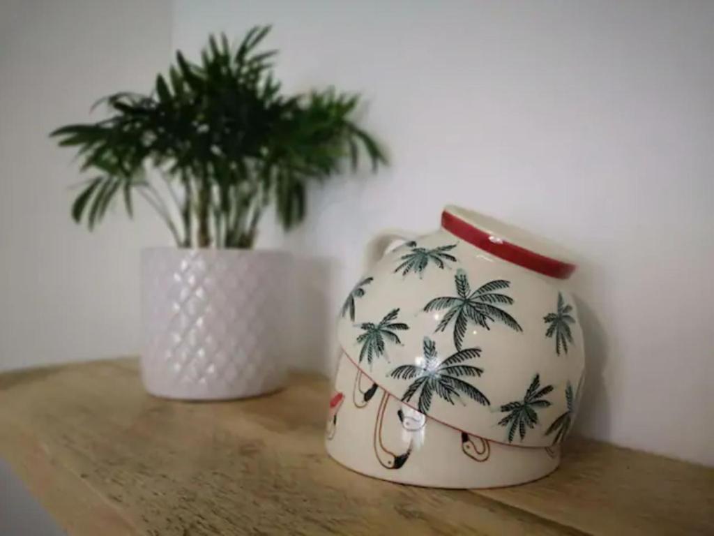 a vase sitting on a table next to a plant at The Little House, boutique home near the sea in Chichester
