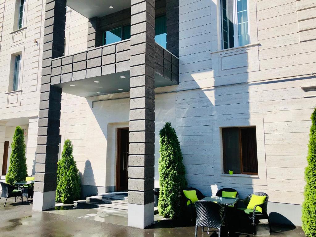 a building with chairs and a table in front of it at Grand Fortune Hotel in Yerevan