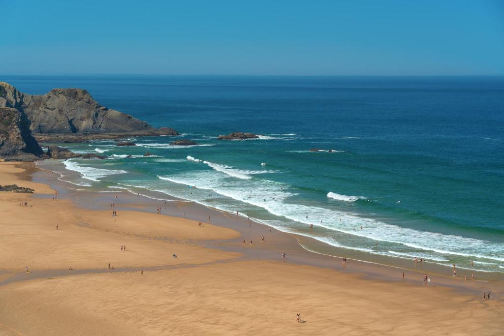 a group of people on a beach near the ocean at Sunset Room - Costa Vicentina in Odeceixe