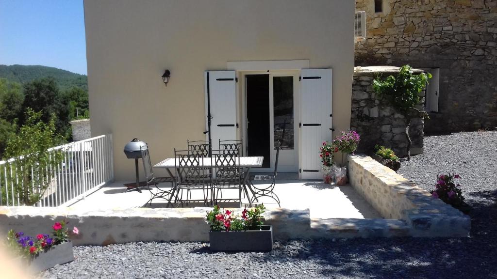 a patio with chairs and flowers in front of a building at La Magnanerie de Fontfreyde in Gras