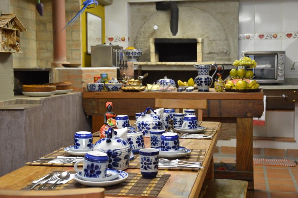 a kitchen with blue and white cups and plates on a table at Pousada Recanto dos Ingleses in São Paulo