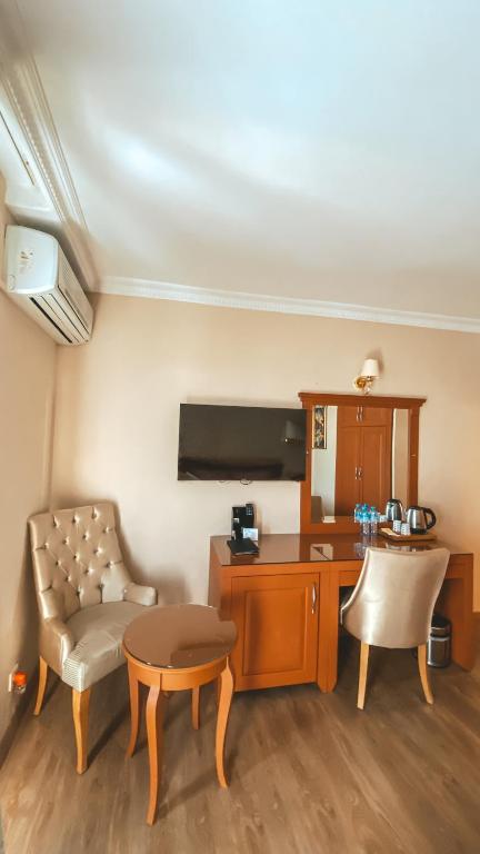 a living room with a chair and a table and a desk at Premier Vista Hotel in Silivri