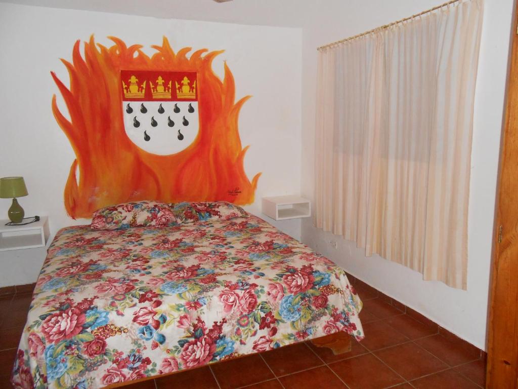 1 dormitorio con cama con edredón y tabla de planchar en Casa Monika, en Sosúa