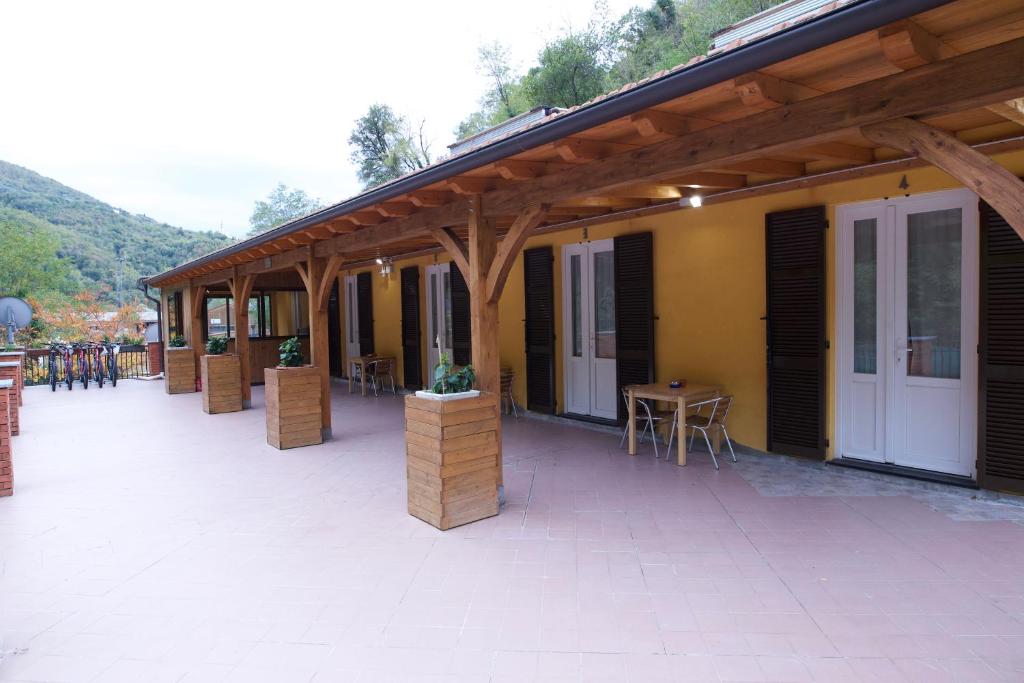 ein Gebäude mit einer Terrasse mit Tischen und Stühlen in der Unterkunft Loggia Piani Nuovi in Carasco