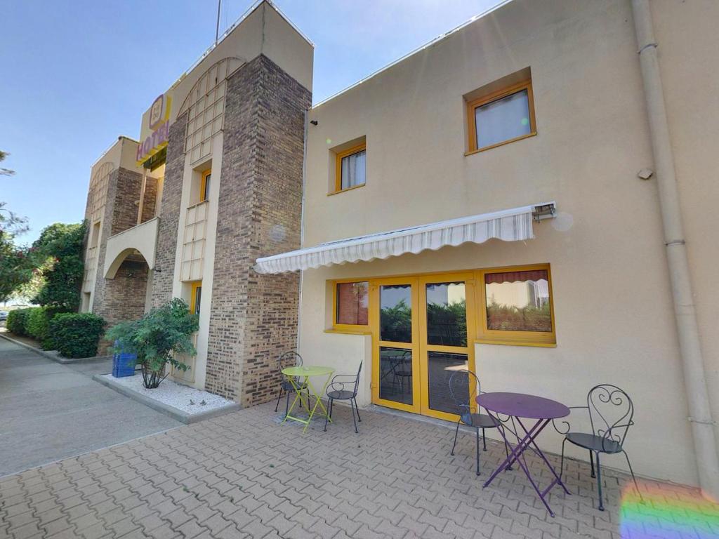 a group of chairs and tables outside of a building at The Originals Access, Hôtel Béziers Est (P'tit Dej-Hotel) in Villeneuve-lès-Béziers