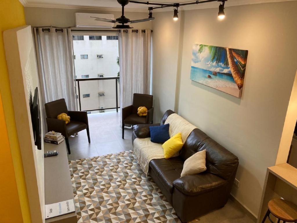a living room with a brown leather couch and chairs at Fb HOME Guaruja- Apartamento proximo as praias da Enseada e Pitangueiras - WI FI in Guarujá