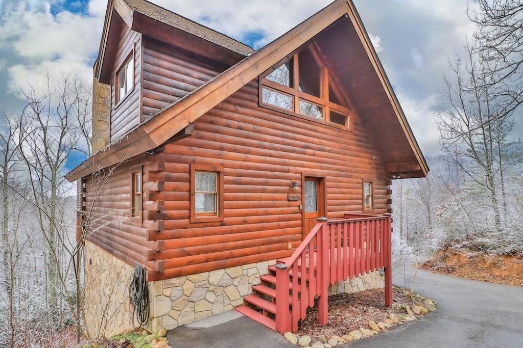 a log cabin with a staircase in front of it at Romantic, Honeymoon Cabin In The Smokies! in Gatlinburg