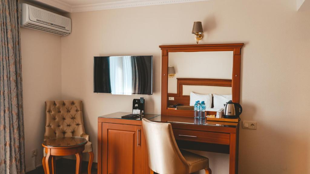 a hotel room with a desk and a mirror at Premier Vista Hotel in Silivri