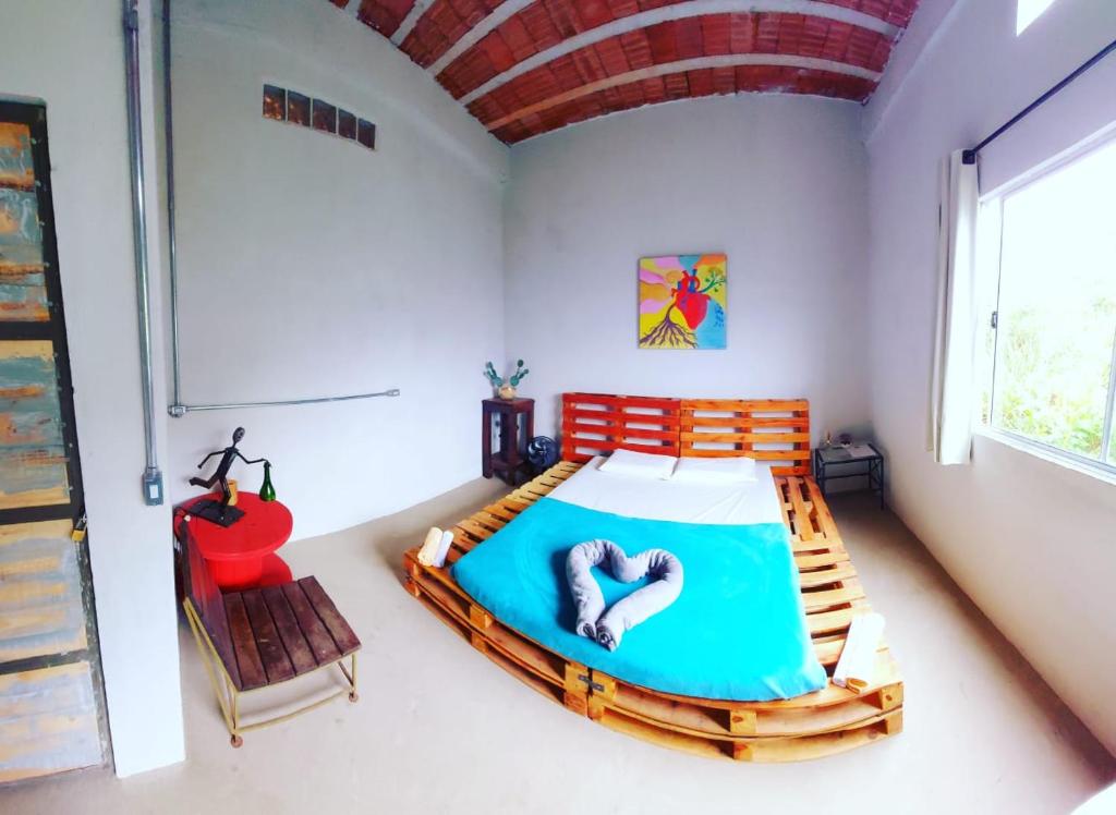 a bedroom with a bed and a red chair at Pousada Vila da Serra - Quarto do Amor in Nova Lima