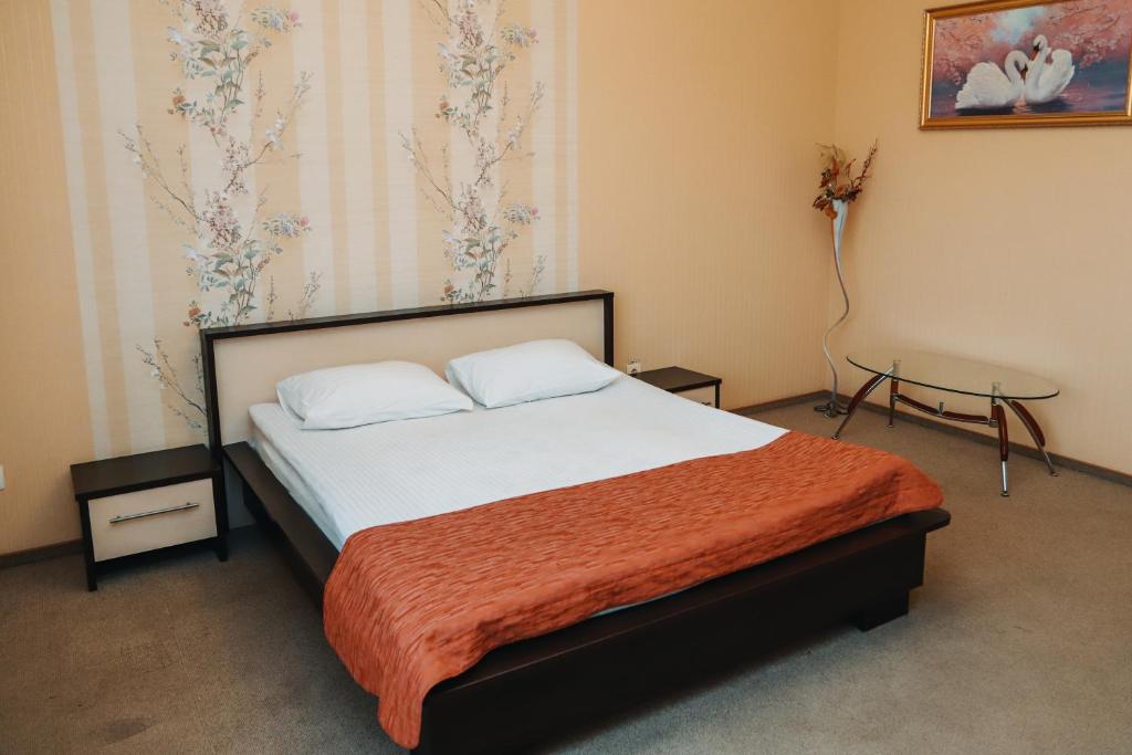 a bedroom with a bed with a orange blanket at Готель Релакс in Korostyshiv