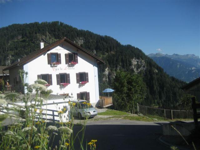 una casa bianca con una macchina parcheggiata di fronte di on a quiet location, beautiful, spacious holidayhouse, only for holidays, with a fantastic view, perfect for skiing, walking and hiking a Scheid