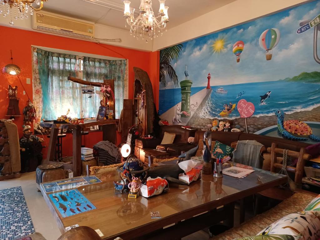 a living room with a table and a painting on the wall at Hualien Seaside B&amp;B in Hualien City