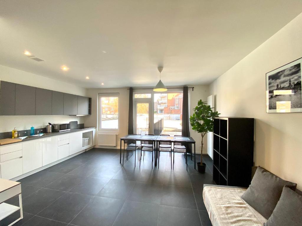 una cucina e un soggiorno con tavolo e divano di Isabel Apartments ad Anversa