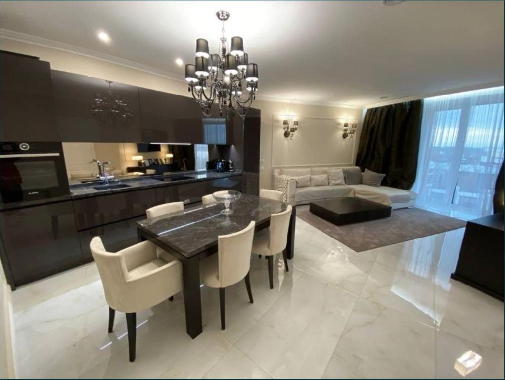 una cucina e una sala da pranzo con tavolo e sedie di Lux 1-bedroom panoramic view Most City Center area a Dnipro