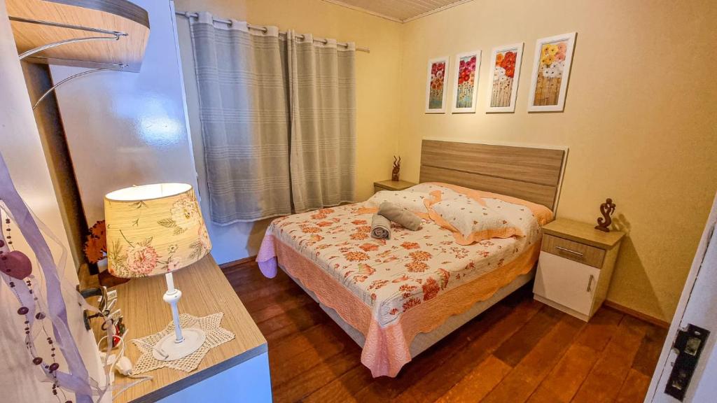 a small bedroom with a bed and a lamp at Apartamento 2 Quartos até 5 pessoas - Gramado in Gramado