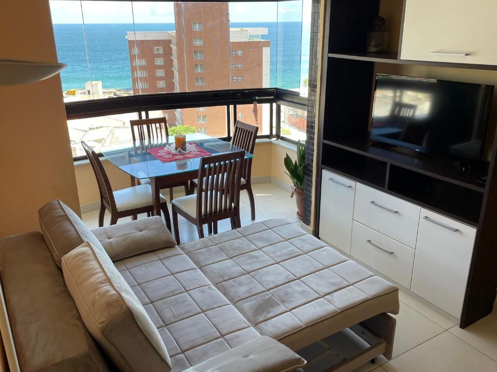 uma sala de estar com um sofá e uma mesa com cadeiras em MarAzul Residence em Salvador