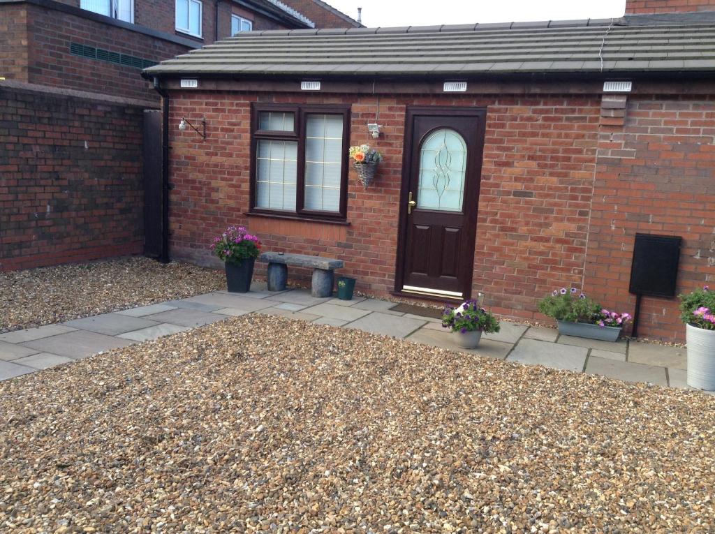 a brick house with a black door and a patio at The Anfield Apartment in Liverpool