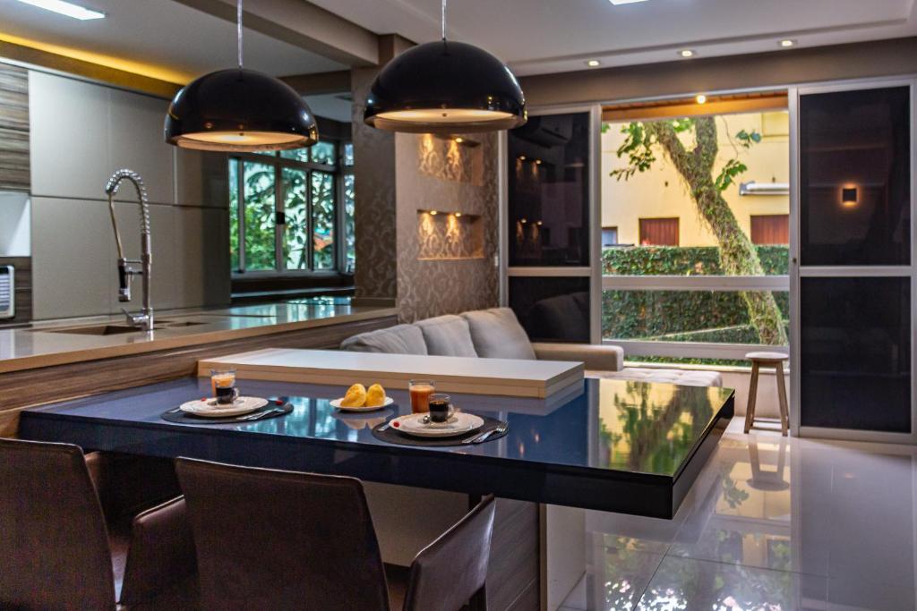 uma cozinha e sala de estar com uma mesa com comida em Apartamento charmoso e bem localizado no Centinho da Lagoa da Conceição N759 em Florianópolis