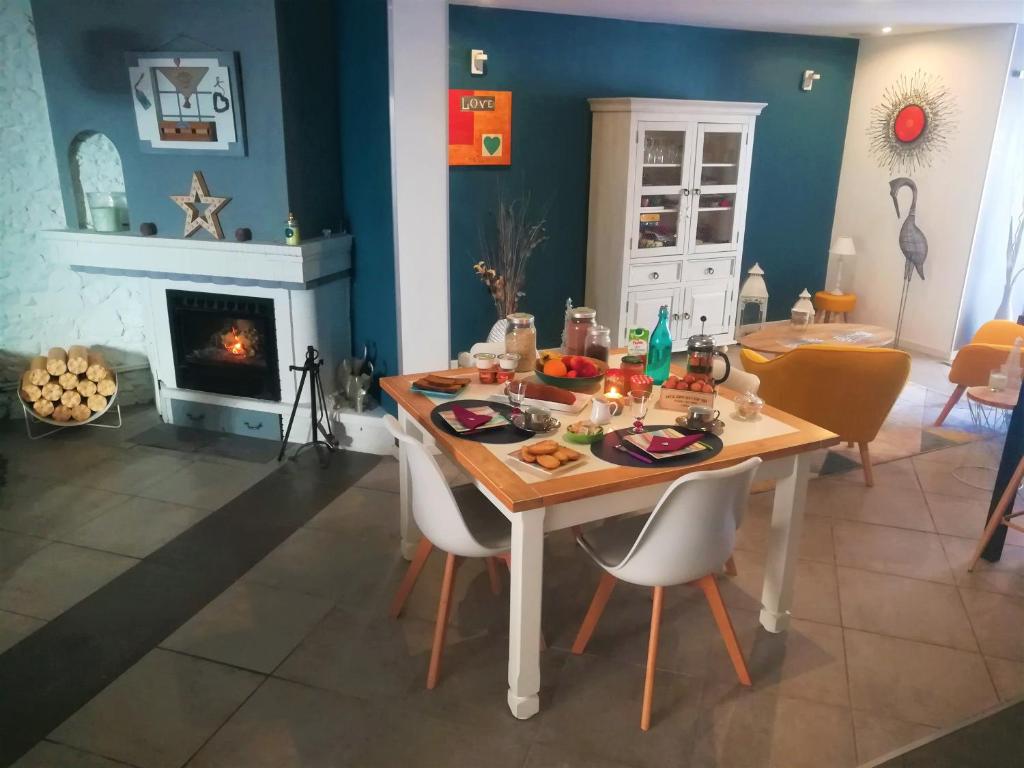 a dining room with a table and a fireplace at Au Monde de Maëlle in Saint-Hippolyte