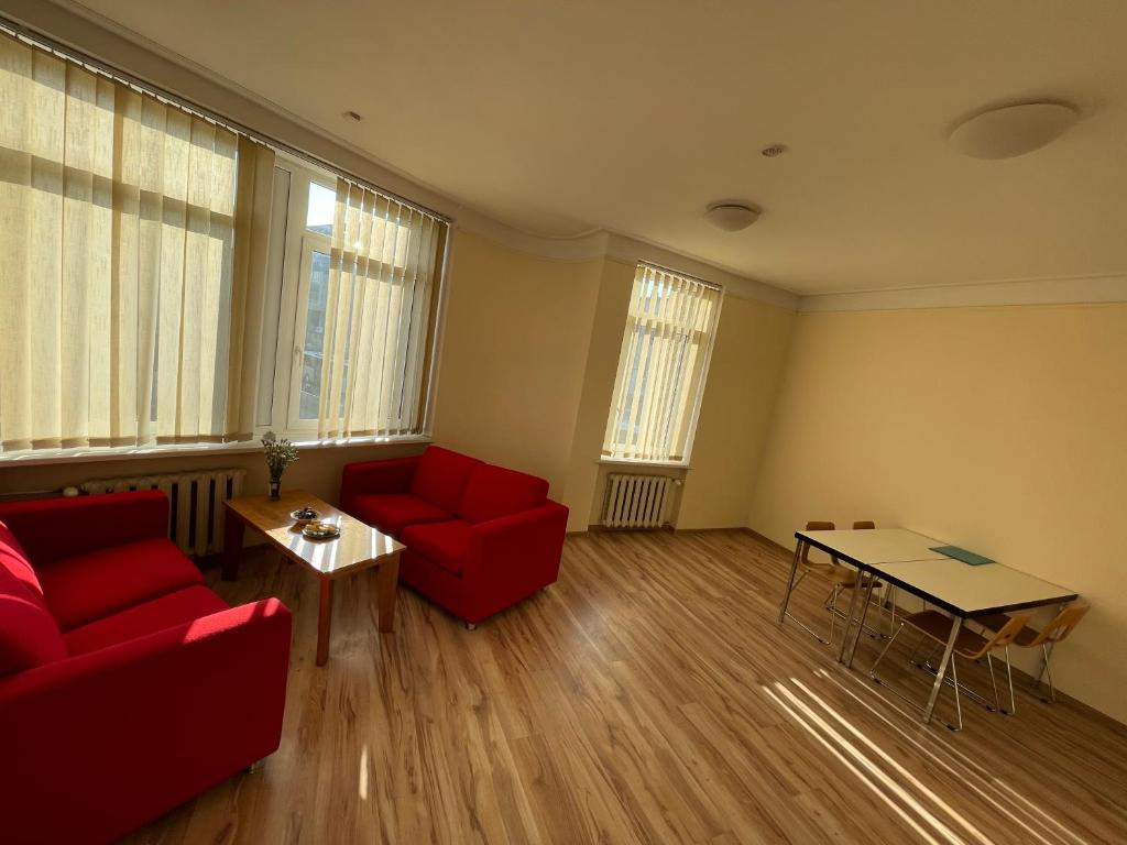 a living room with a red couch and a table at Mr Jo’s hostel in Kaunas