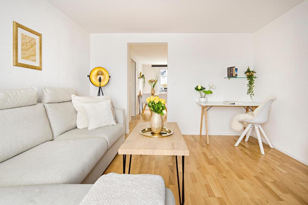 a living room with a white couch and a table at EH Apartments Venus in St. Gallen